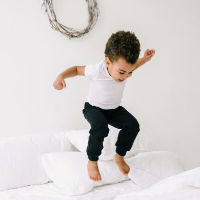 niño saltando en la cama oudiendo caerse y tener un accidente doméstico