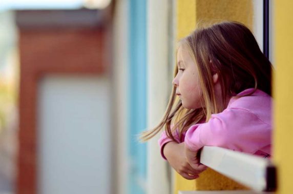 niña asomándose por un balcón