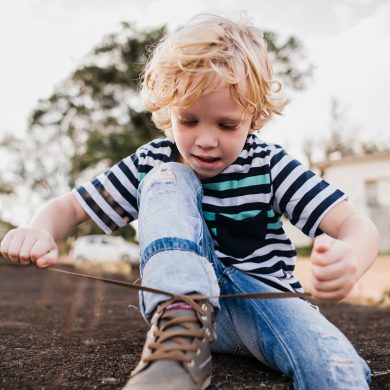 Boy learning to tie his shoelaces